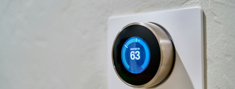 Temperature controller on a white wall that displays the set temperature